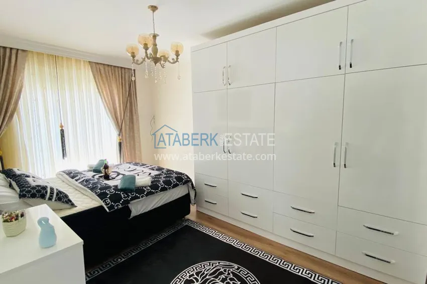 Приобрести Квартира в Махмутларе меблированная с отдельной кухней и видом на горы располагает собственной охраняемой территорией с инфраструктурой 12 