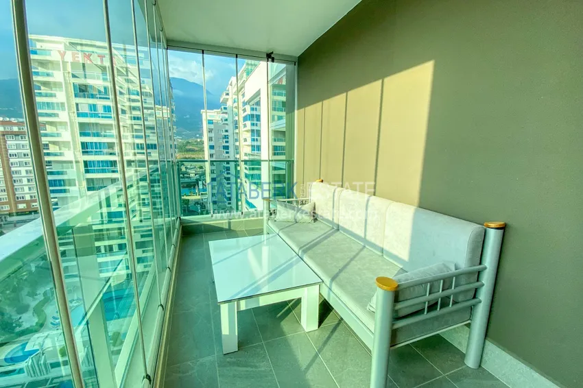 Приобрести Квартира в Махмутларе с новой мебелью и застекленным балконом в комплексе комфорт-класса 19 