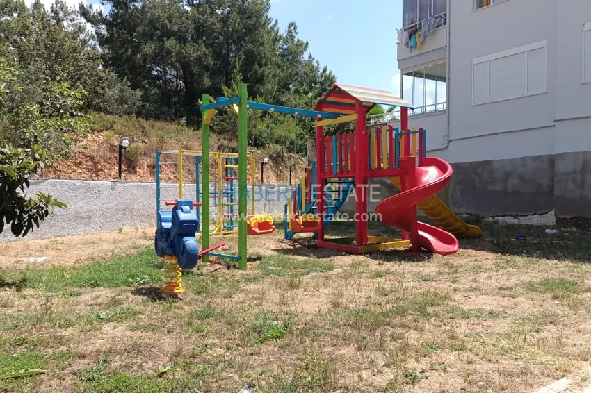 Меблированная квартира с выходом в сад и видом на горы в Алании, район Оба в уютном жилом комплексе 12 