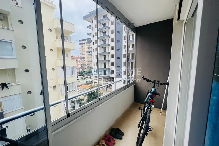 Приобрести Просторная двухкомнатная квартира с тремя застеклёнными балконами в Алании, район Махмутлар 10 